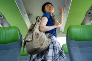 Woman standing with a backpack inside a bus looking around