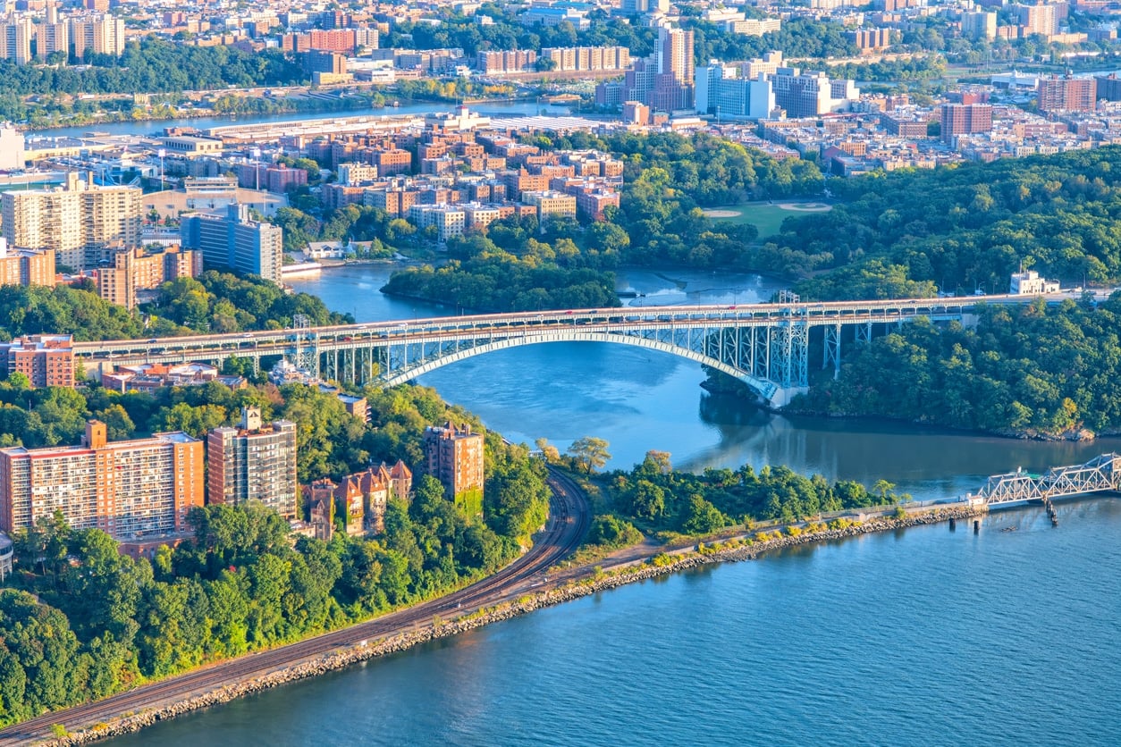 The Henry Hudson Bridge spanning the mouth of the Harlem River as it begins from the Hudson River joining New York City's Inwood, Manhattan neighborhood and south Yonkers in Westchester County, New York, shot via helicopter from an altitude of about 900 feet over the Hudson River.