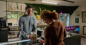 Budtender Shows a Customer a Jar of Marijuana Nuggets